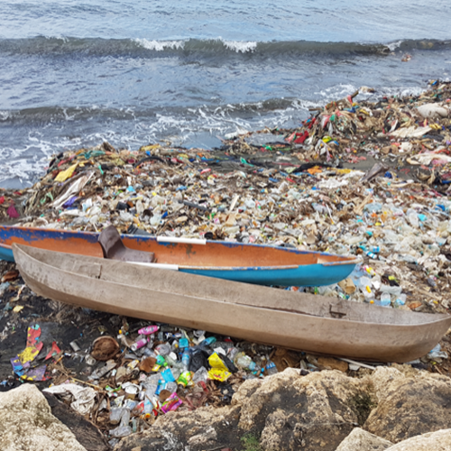 two boats on beach with lots of litter