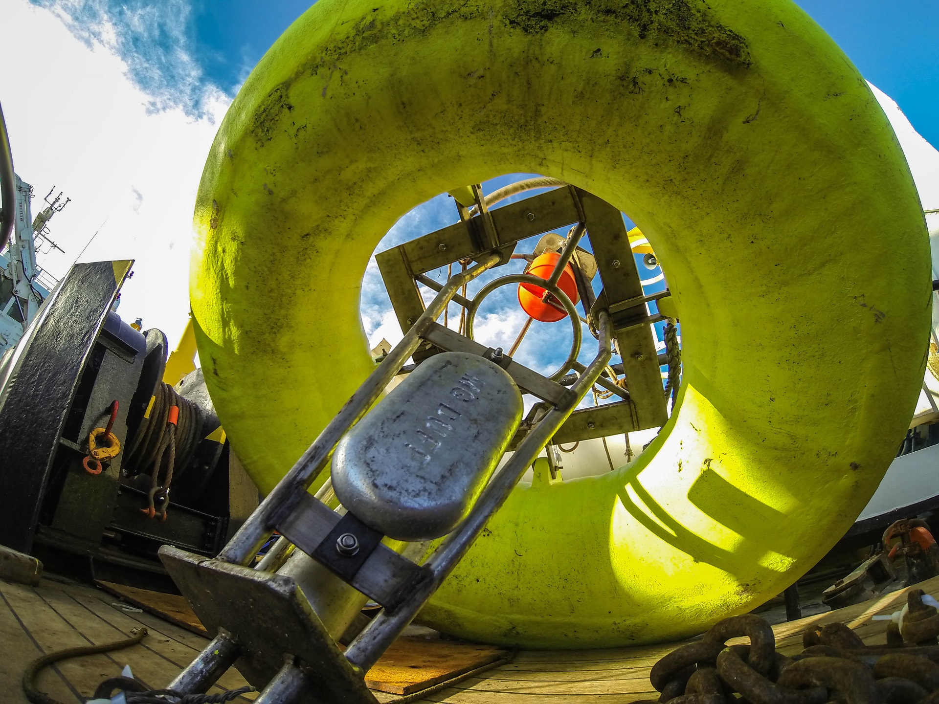 a yellow buoy containing scientific equipment on the deck of a boat