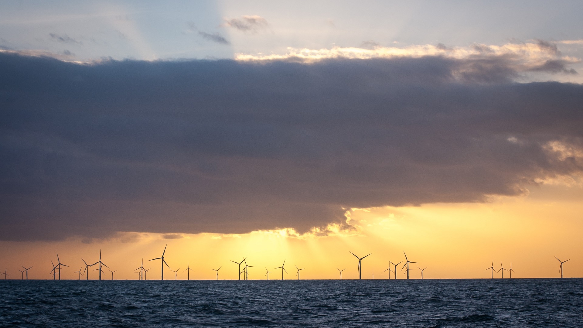 wind turbines in front of a sunrise