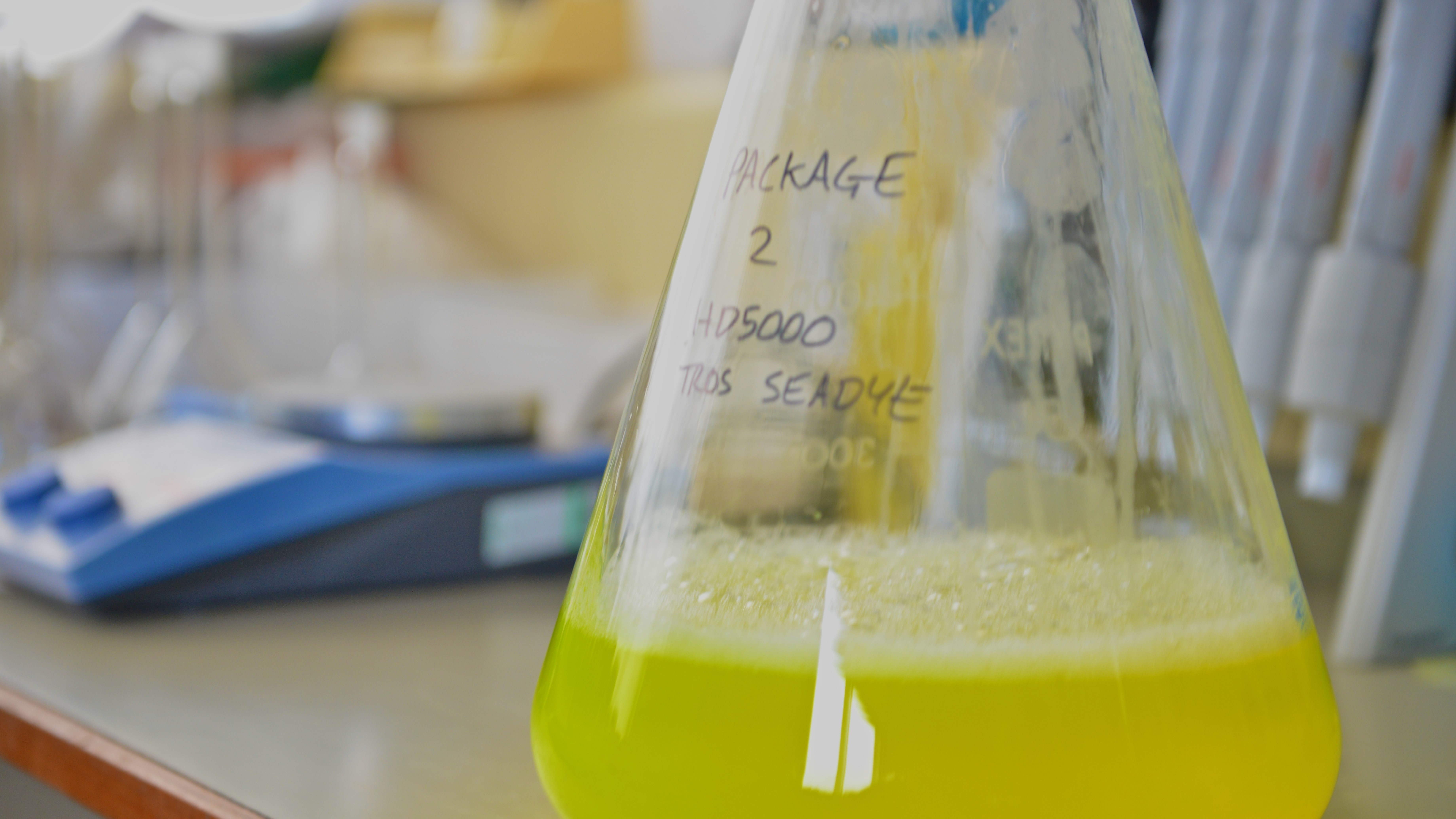 a beaker in a lab with yellow liquid