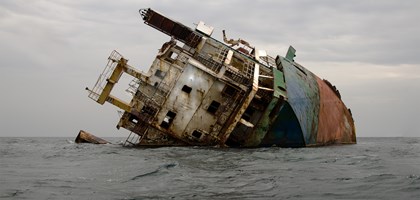 A ship wreck in the ocean, lopsided and starting to rust