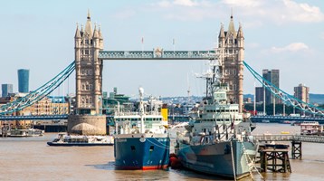 The Cefas Endeavour docked on the Thames in front of London Bridge on a clear, sunny day in London