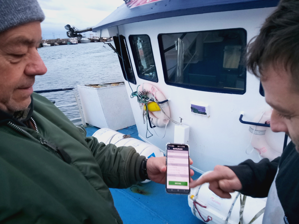 Cefas Scientist Fisheries Observer, Allen Searle, demonstrating the app to skipper, Ed Jones