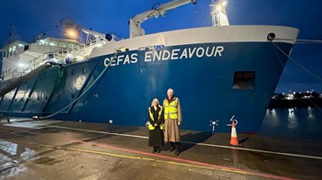 Two people stood in front of a boat