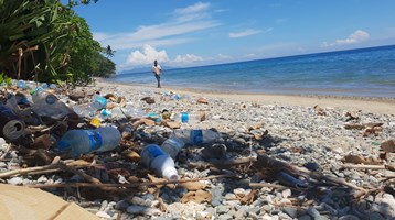 man walking on beach with litter