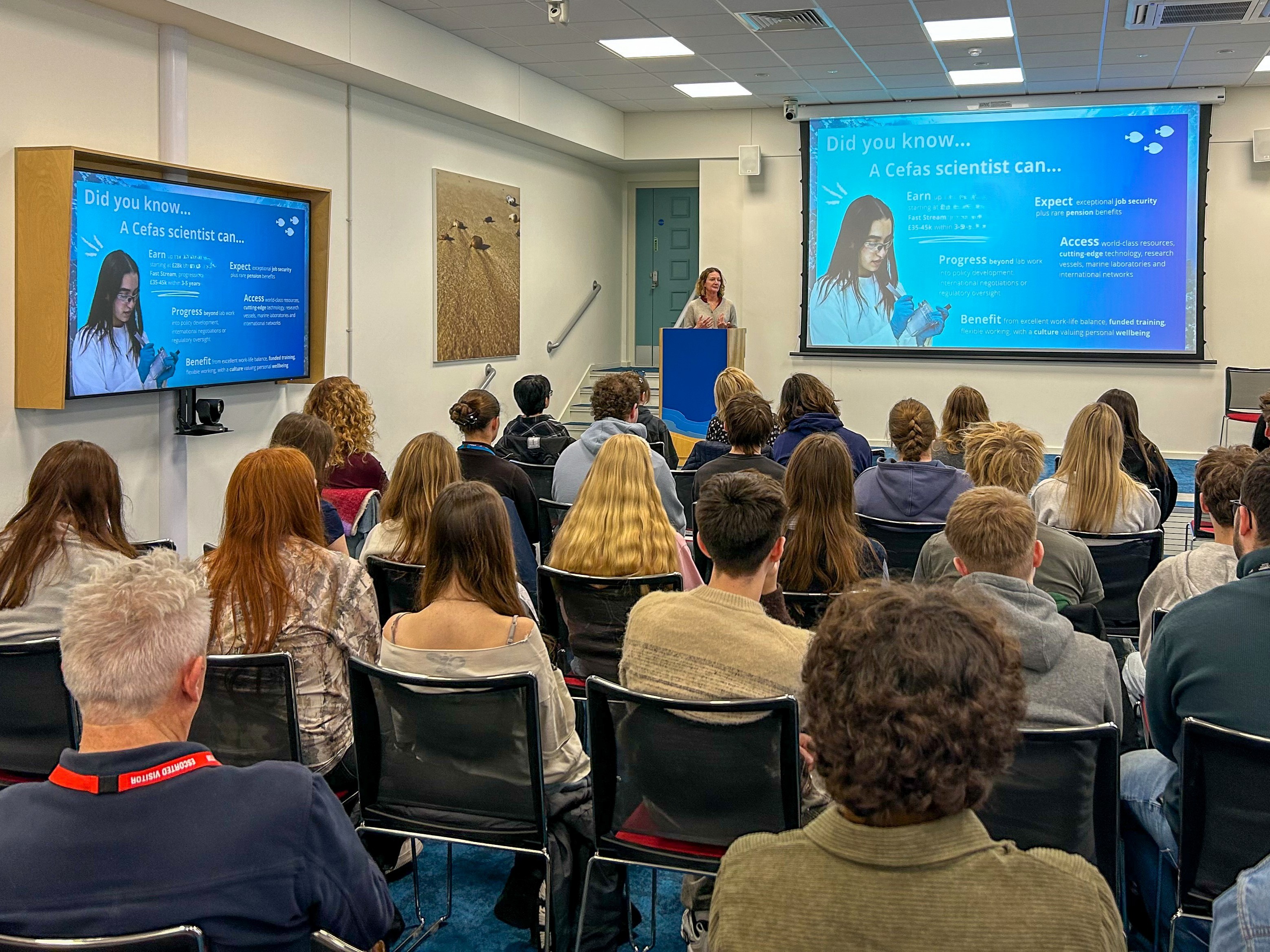 Students seated facing a screen showing a careers presentation