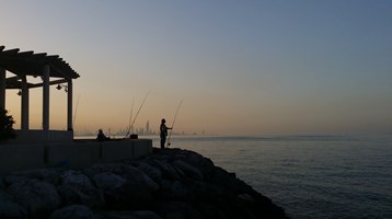 two people at sunset fishing