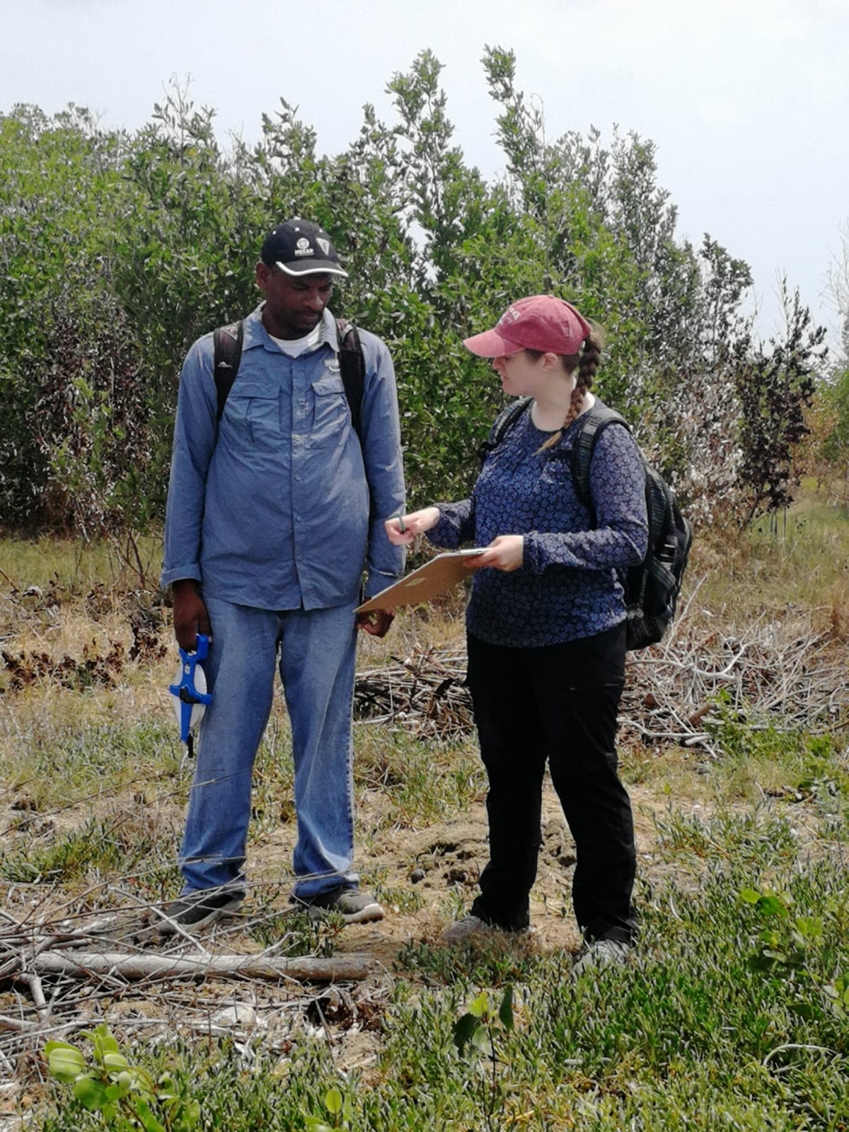 two people by a beach with a clipboard