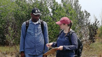 two people by a beach with a clipboard