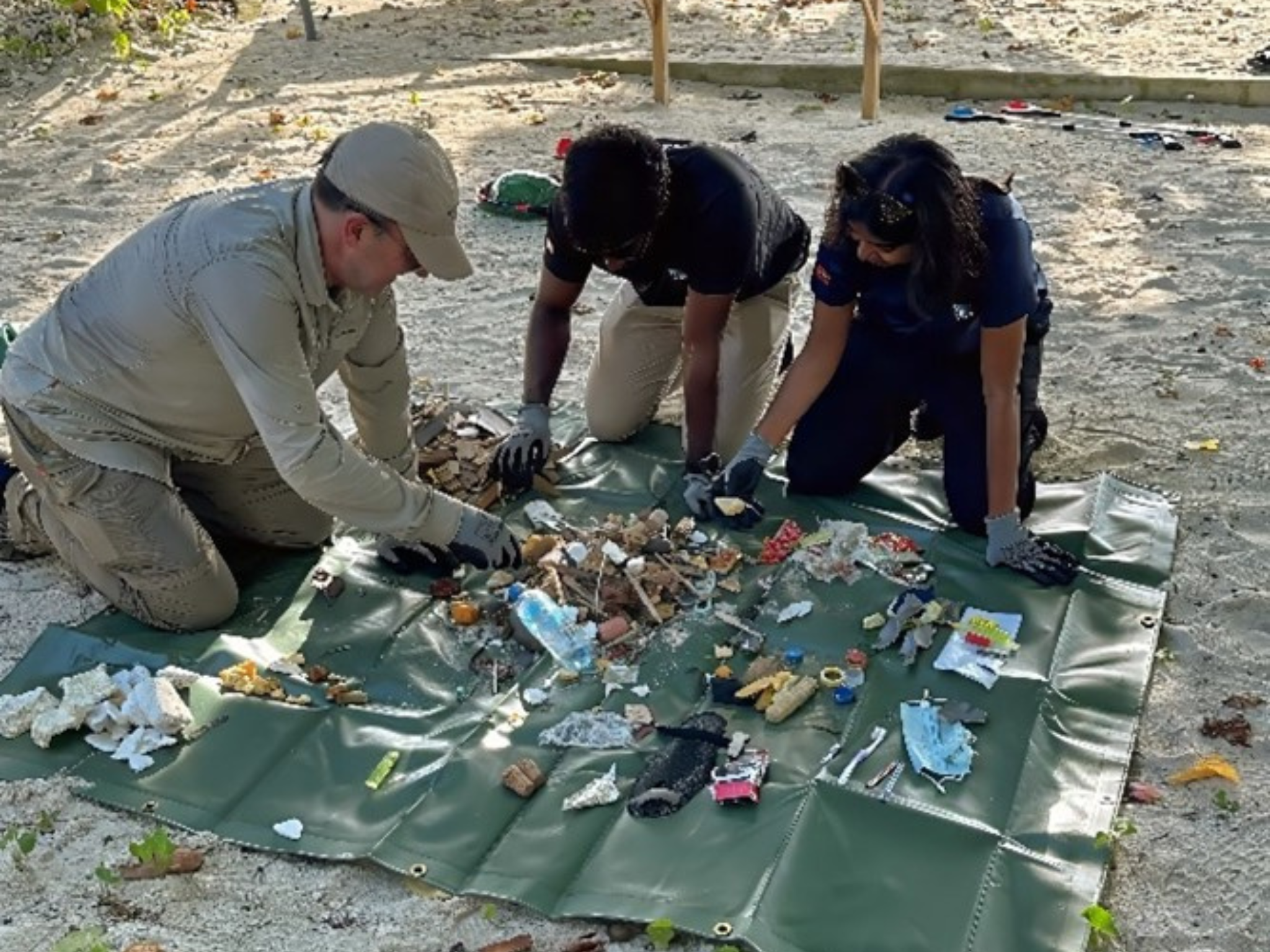 A group of people stood behind a table after a meeting, smiling and posing next to each other for a photograph