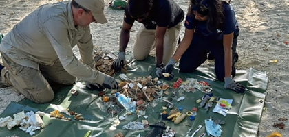 A group of people stood behind a table after a meeting, smiling and posing next to each other for a photograph