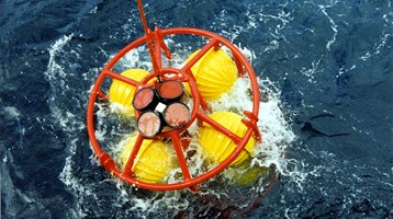 a man lowers a camera underwater