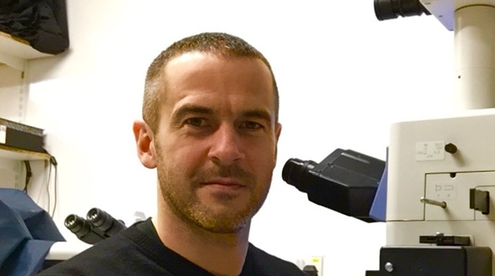 a man next to a microscope